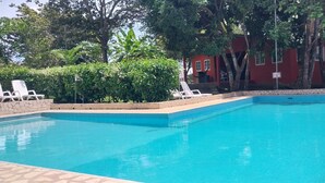 Una piscina rectangular con borde de azulejos, rodeada por un marco de piedra.