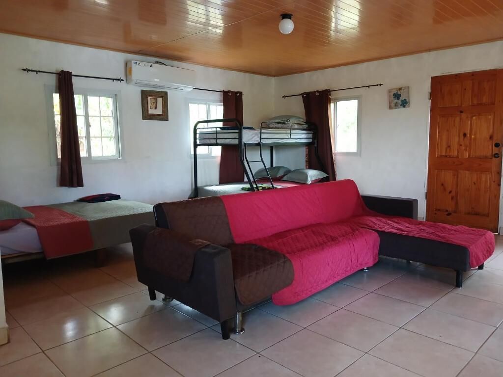 Una habitación con literas, un sofá y una ventana.