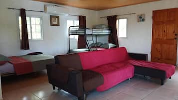 Una habitación con literas, un sofá y una ventana.