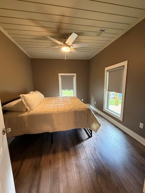 A bedroom with a bed, a ceiling fan, and a window. - Blue House on the Corner in Old Higden Perfect 4-bedroom house with AC (Higden)