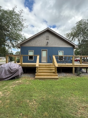 A two-story wooden building with a blue exterior, a front door, and a small porch with a set of stairs leading up to it. - Blue House on the Corner in Old Higden Perfect 4-bedroom house with AC (Higden)