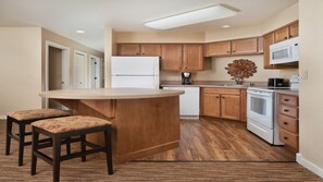 A kitchen with wooden cabinets, a white refrigerator, a microwave, a stove, and a coffee maker. - Big Bear Ski & Lake Retreat, WorldMark 2BR Suite w/ Fireplace & Hot Tub (Big Bear Lake)