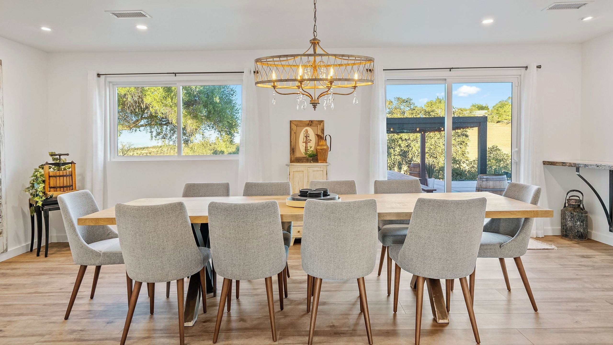 A dining area with a large table, six chairs, and a chandelier.