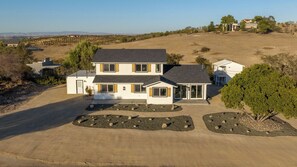 A two-story house with a driveway and landscaped areas. - The Shire at Baggins Hill by Avantstay Hot Tub + Playhouse + Cornhole 10 Private Acres (Templeton)