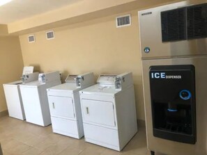 A laundry area with four white washers and a black ice dispenser. - Surf N Sun spectacular oceanfront studio w/balcony (Daytona Beach)