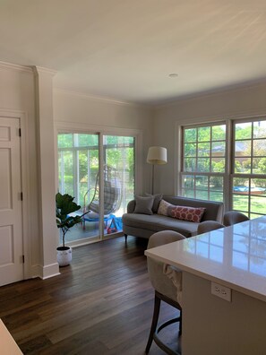 A spacious kitchen with a large island, a dining area with a table and chairs, and a sliding glass door leading to a patio with outdoor furniture. - Spacious, Fully Renovated Sumter Home Near CCTC, USC Sumter & Prisma Health (Sumter)