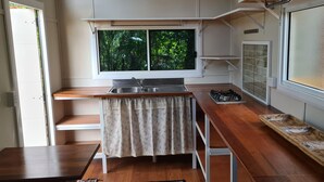 A compact kitchen with a window, a sink, and a stove.