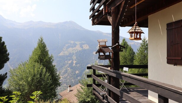 A wooden balcony with a view of a mountainous landscape. - Outside: Apartment located on the ground floor of a chalet, with private garden, outdoor furniture a (St-Luc)