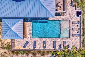 A rooftop pool area with multiple lounge chairs and a small deck with tables and chairs. - Sugar Magnolia! Beach Front, Private Pool, Free Beach Gear! (St. George Island)