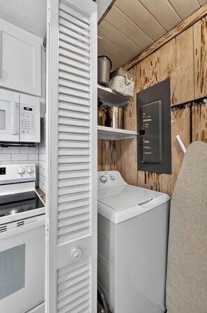 A compact laundry room with a washing machine, a microwave, and an oven. - Sugar Magnolia! Beach Front, Private Pool, Free Beach Gear! (St. George Island)