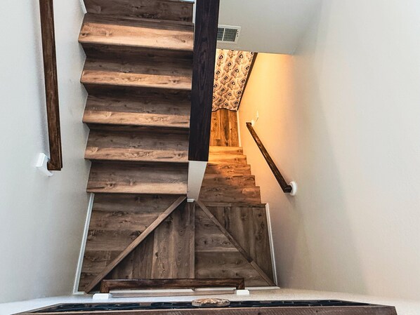 A wooden staircase with a handrail, leading to an upper floor.