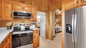 A kitchen with wooden cabinets, a stainless steel refrigerator, a microwave, and a stove. - 3BR mountain-View cabin with hot tub, fireplace, WiFi, and Views (West Jefferson)