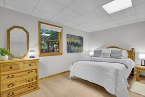 A bedroom with a bed, a dresser, a mirror, and two paintings on the wall. - 3BR mountain-View cabin with hot tub, fireplace, WiFi, and Views (West Jefferson)