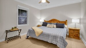 A bedroom with a bed, a nightstand, a bedside table, a ceiling fan, and a window with blinds. - 3BR mountain-View cabin with hot tub, fireplace, WiFi, and Views (West Jefferson)