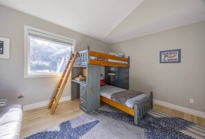 A child's bunk bed with a ladder, a desk, and a window. - Sanctuary at Seal Rock (Seal Rock)