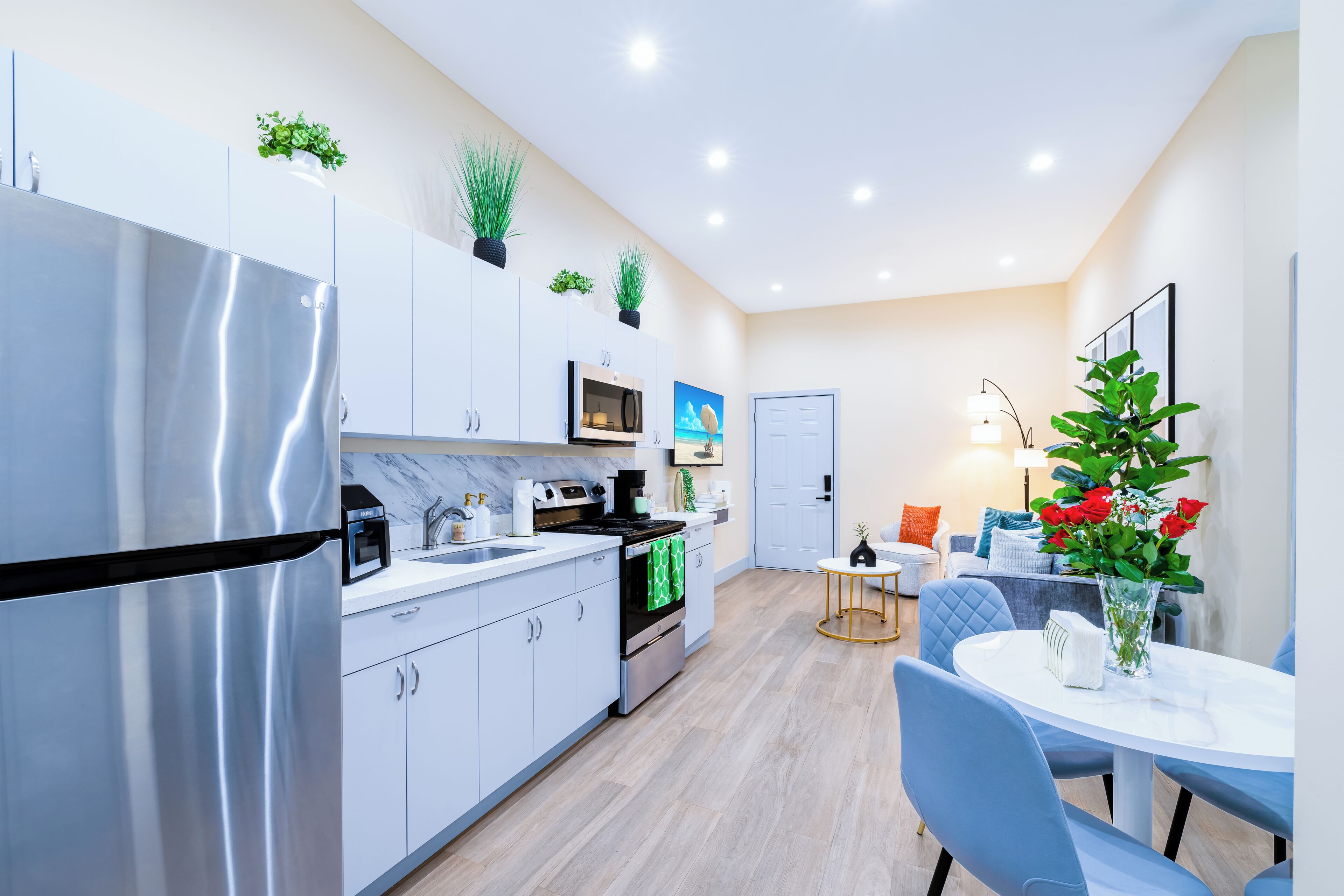 Une cuisine moderne équipée d’un réfrigérateur, d’un four à micro-ondes et d’une cuisinière. Un coin repas avec une table et des chaises est également disponible.