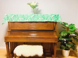 A wooden piano with a white furry ottoman and a potted plant beside it. - Spacious 5-bedroom house San Diego by UCSD La Jolla DelMar CarmelValley Qualcomm (San Diego)
