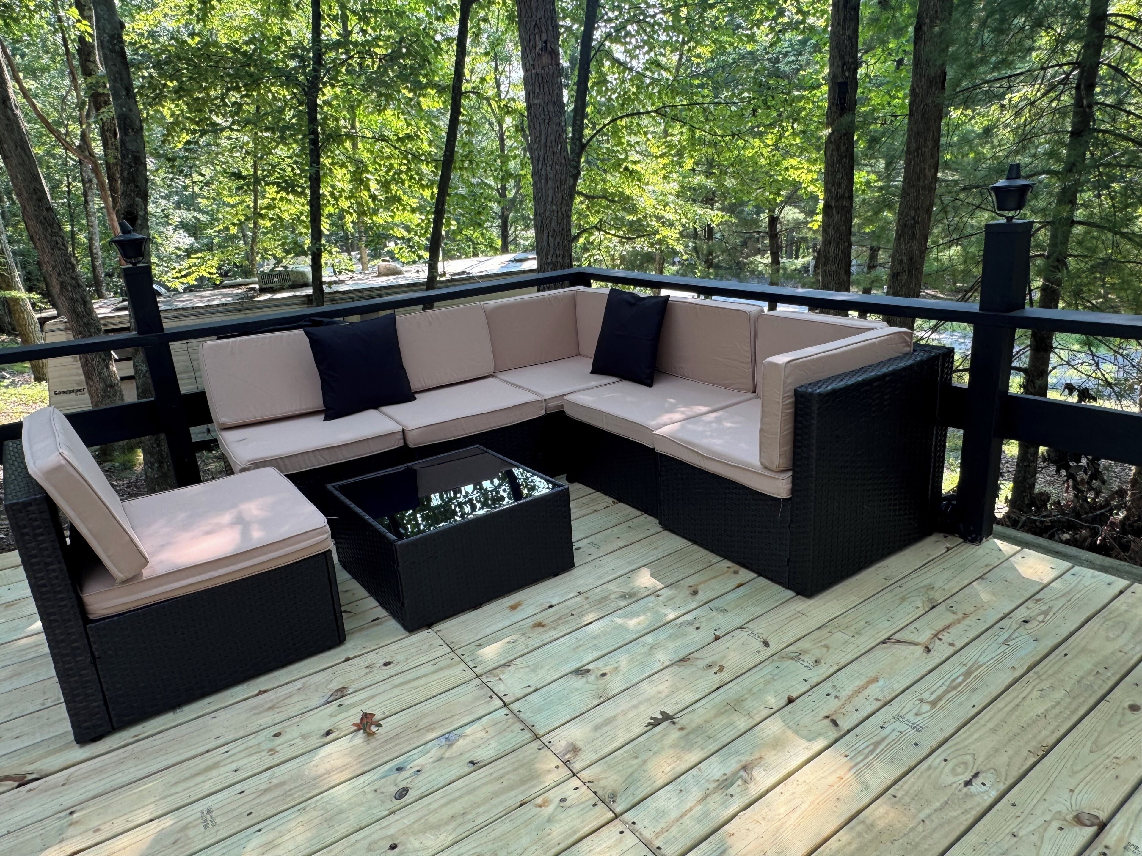 An outdoor deck with a sectional sofa and a coffee table.