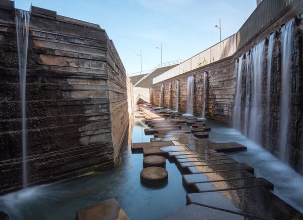 Un canal d’eau bordé d’escaliers en pierre et de cascades.