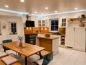 Een moderne keuken met een houten eettafel, inbouwapparatuur en een raam.