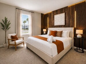 A hotel room with a large bed, a chair, a lamp, and a window with curtains. - Retiro Moderno 5BR Windsor Cay | Piscina Privada + Sala de Jogos (Clermont)
