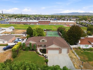 Een woonwijk met huizen, een tennisbaan en een schoolgebouw.