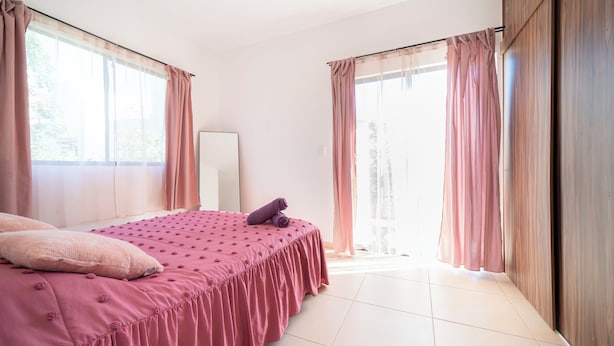 A bedroom with a bed, a mirror, and a view of the outdoors. - Apartment in Pto. Morelos Rooftop (Puerto Morelos)