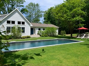 A residential property with a swimming pool, a lawn, and a house with a porch. - Waterfront 3 Bedroom Marina Retreat • East Hampton • HeatedPool (East Hampton)
