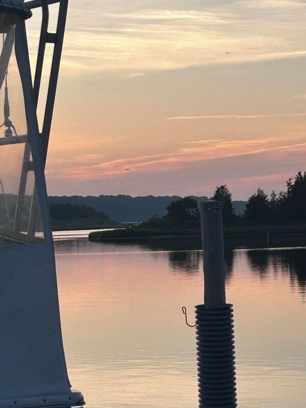 Una masa de agua tranquila con un muelle y una estructura metálica en primer plano.