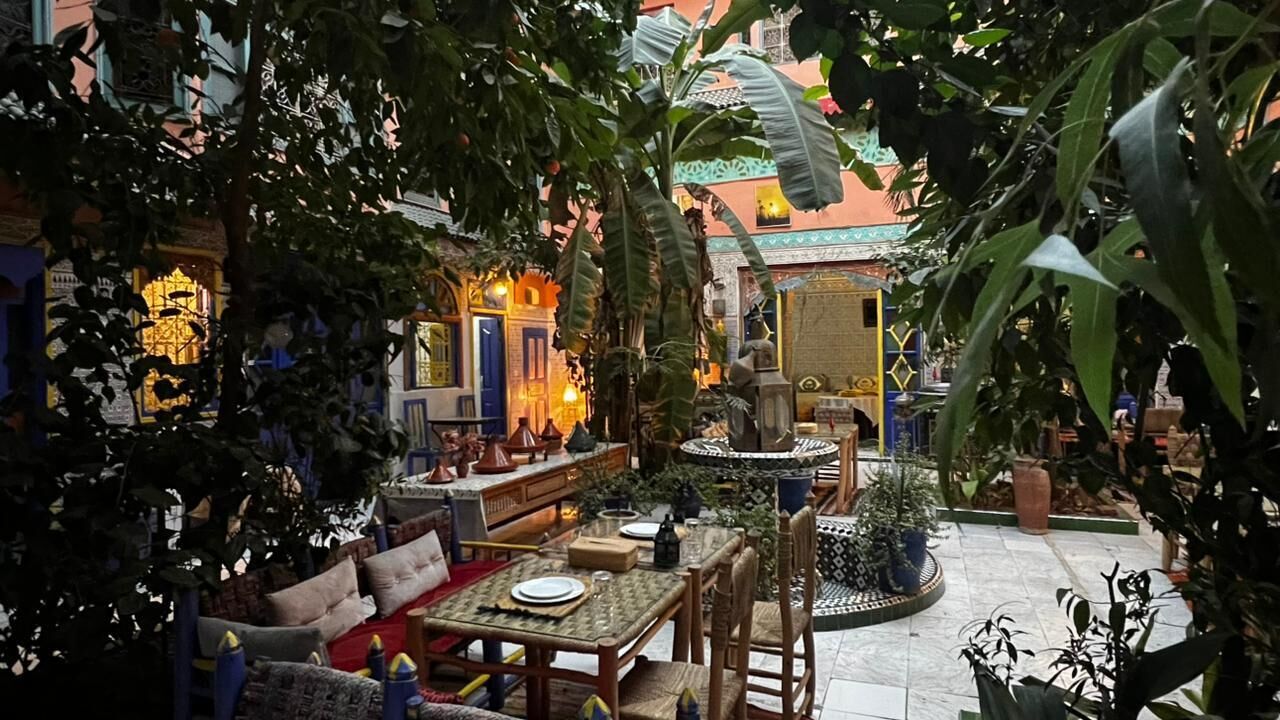 A courtyard with a dining area, seating arrangements, and a fountain.