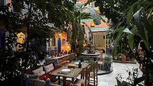 Ein Innenhof mit Essbereich, Sitzgelegenheiten und einem Brunnen.