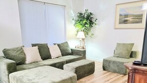 Una sala de estar con un conjunto de sofá, una mesa de centro y una lámpara.