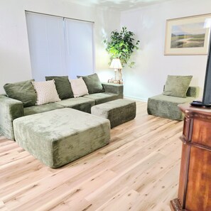 Ein Wohnzimmer mit einer Sofagarnitur, einem Couchtisch und einer Lampe.