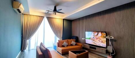 A modern living room with a sofa, a coffee table, a television, and a ceiling fan.
