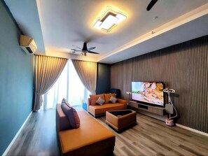 A modern living room with a sofa, a coffee table, a television, and a ceiling fan.