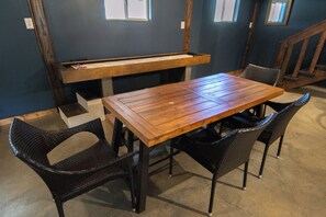 Ein Essbereich mit einem Holztisch und vier Korbstühlen.
