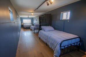 A corridor with three single beds lined up against the wall, each with a bedside table and lamp. - Cozy pet-friendly barn in perfect Rising Fawn near Cloudland Canyon (Rising Fawn)