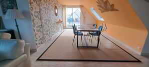 A dining area with a table and chairs, a patterned wall, and a view through a window. - The Oasis Spa - PENVENAN (PENVENAN)