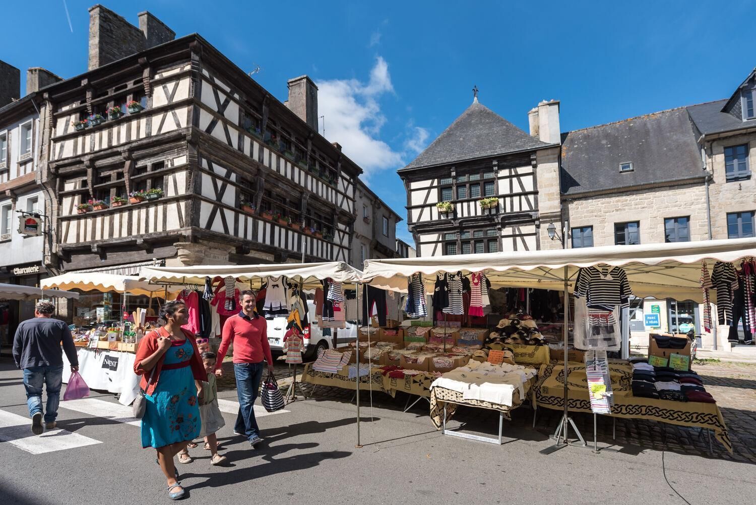 A street market with stalls selling clothes and accessories.