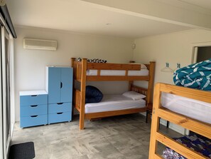 Un letto a castello con un armadio e un tappetino, una finestra e una porta.
