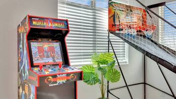 Een Midway-arcadekast voor Mortal Kombat II, een basketbalring en een potplant.