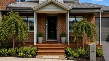 A two-story house with a front porch, a garage, and a mailbox.