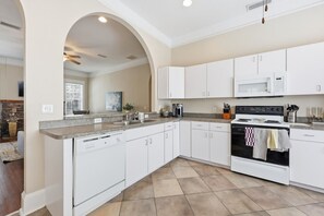 A modern kitchen with white cabinetry, a built-in oven, and a microwave. - Sleeps 15 | Walk to UF, Downtown + 50+ Restaurants (Gainesville)