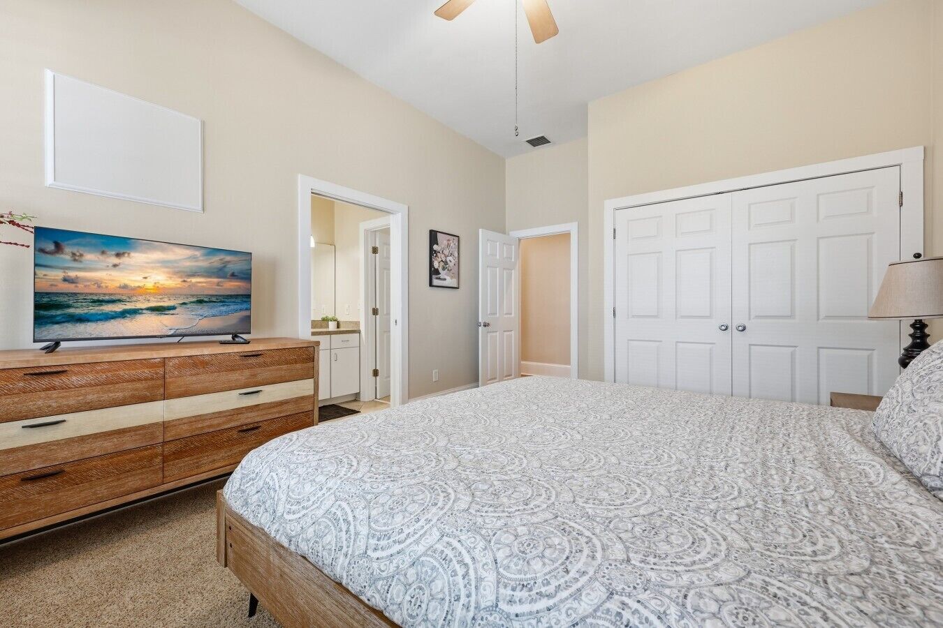 Une chambre à coucher comprenant un lit, une commode, un téléviseur et une armoire.
