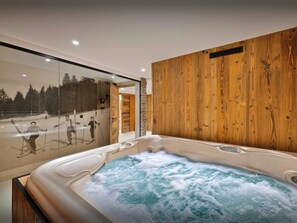 A modern bathroom with a wooden wall, a glass shower enclosure, and a hot tub.
