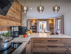 A modern kitchen with a coffee machine, fruit, and a large island.
