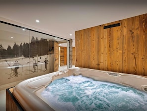 A modern bathroom with a wooden wall, a glass shower enclosure, and a hot tub.