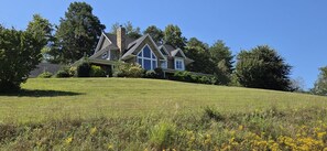 A house on a grassy hill with a clear sky. - Easy Access Mountain Getaway with Panoramic Views (Mars Hill)