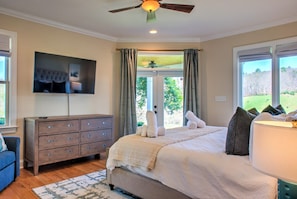 A bedroom with a bed, a dresser, a television mounted on the wall, and a window with curtains. - Easy Access Mountain Getaway with Panoramic Views (Mars Hill)