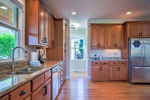 A modern kitchen with wooden cabinets, stainless steel appliances, and a granite countertop. - Easy Access Mountain Getaway with Panoramic Views (Mars Hill)